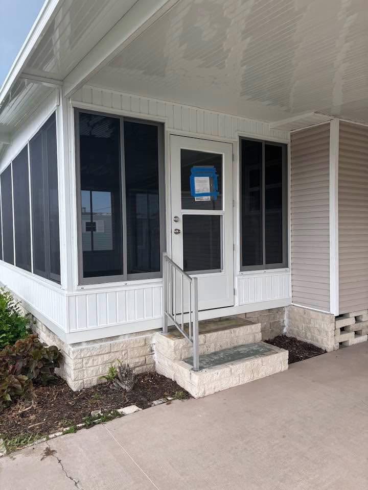 White exterior door installed within a finished residential enclosure by Daly Aluminum